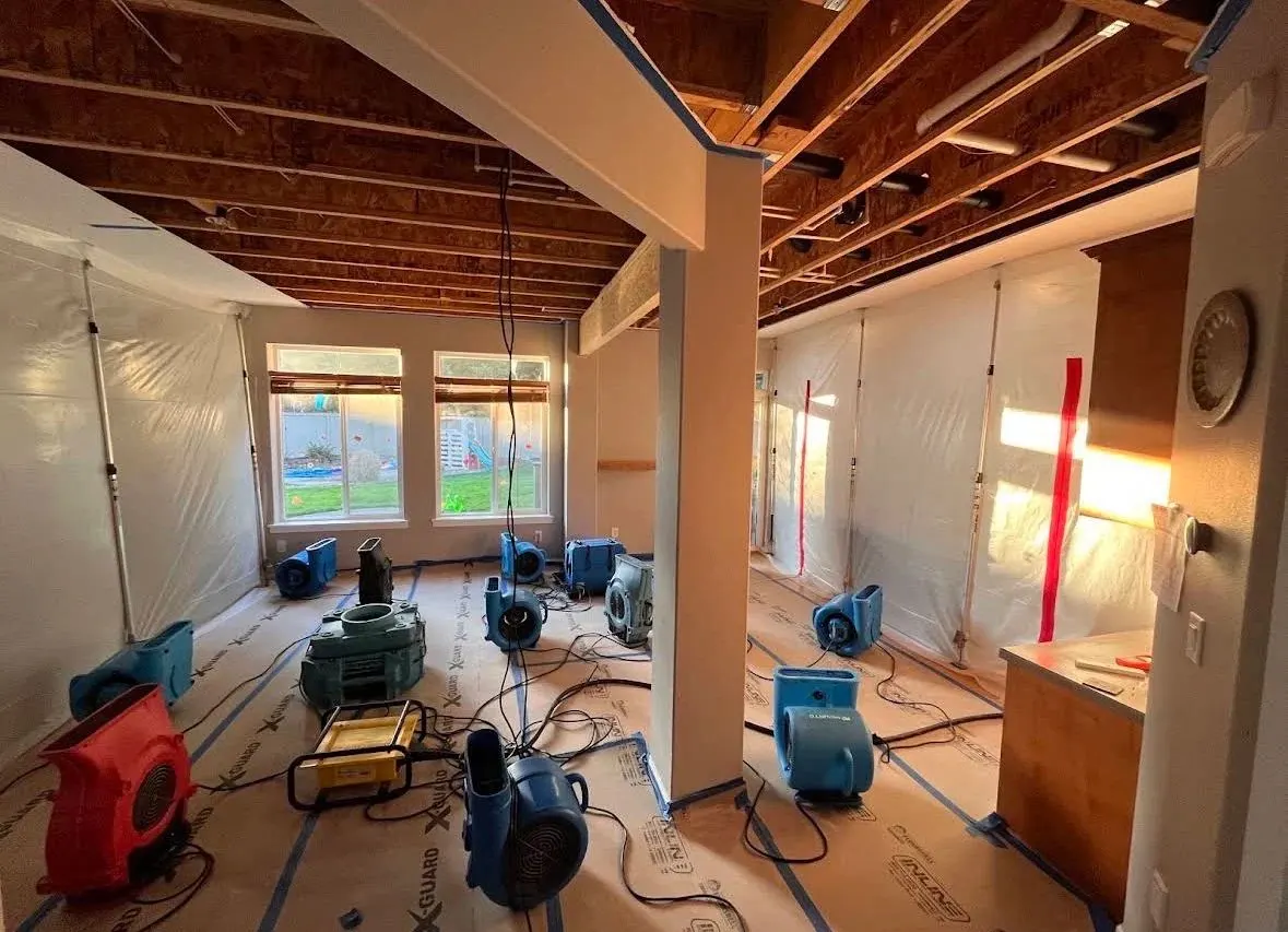 Air movers and plastic containment drying a gutted interior with protected floors