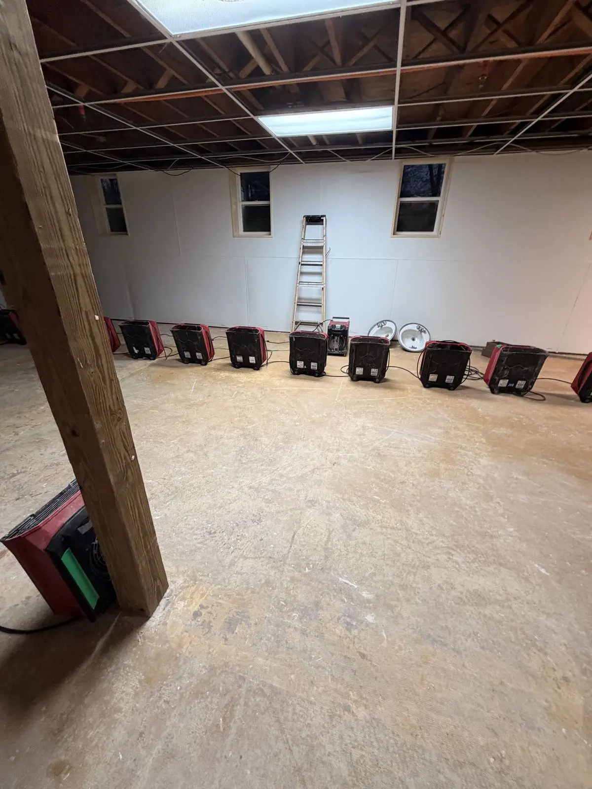 Row of air movers drying a large space after water damage