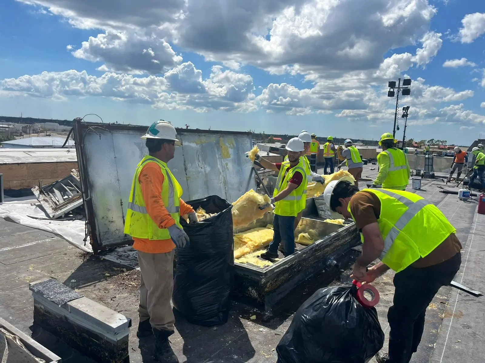 Crew removing insulation on a commercial rooftop