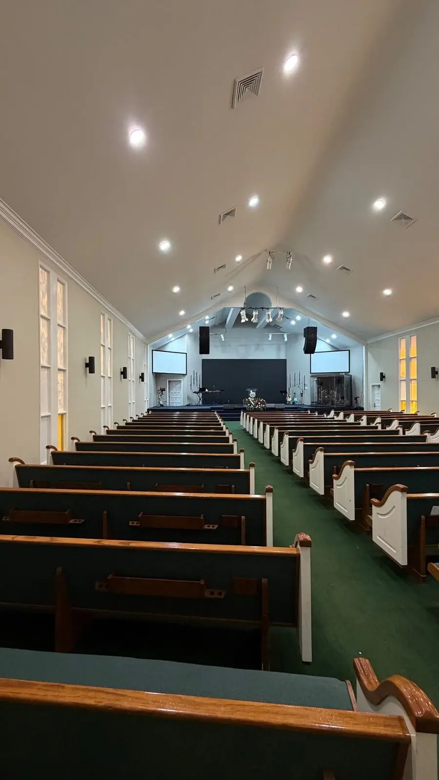 The finished sanctuary with rows of pews and a lit stage