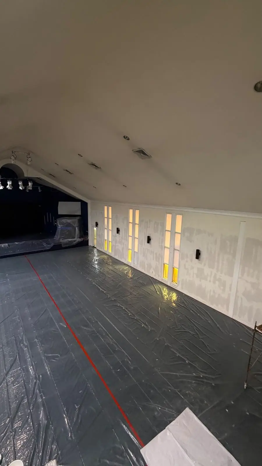 A room prepared for finishing, with the floor covered in plastic and patched walls