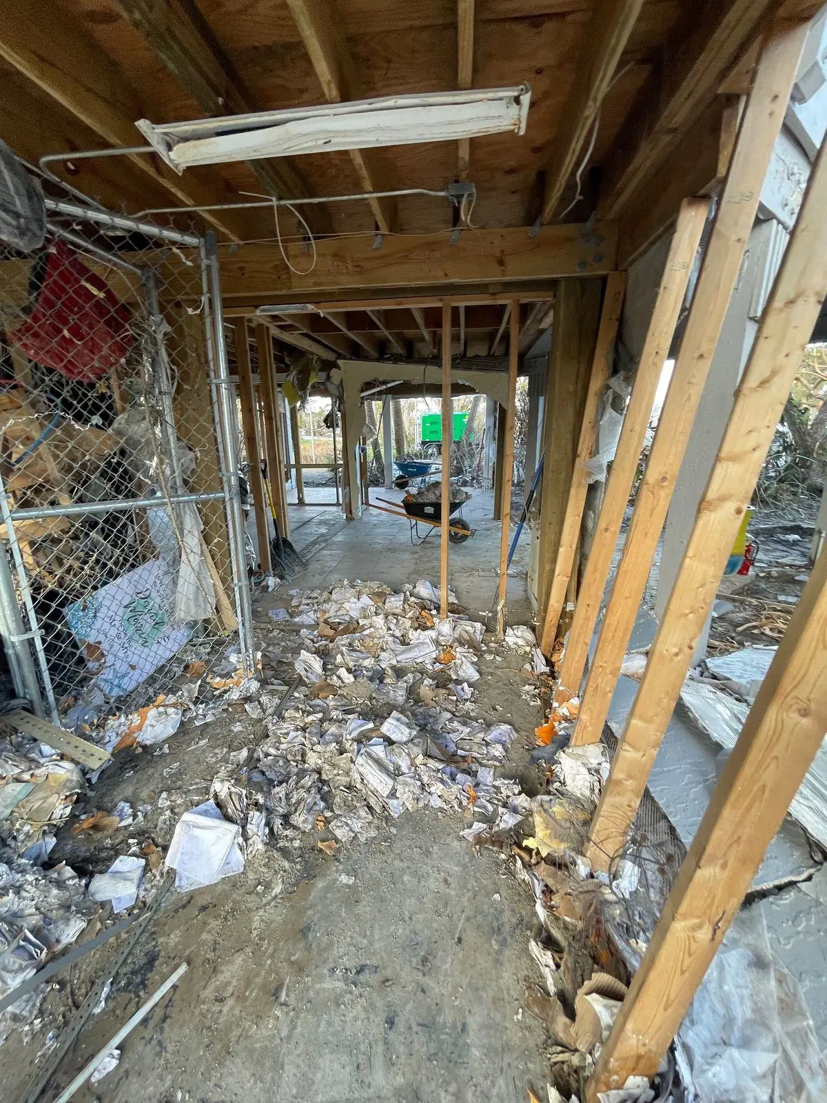 Debris-filled ground level beneath a raised house after a storm